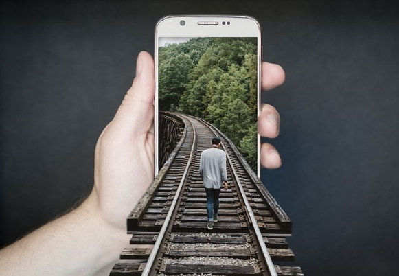 Dieses Bild zeigt einen Weg, der ins Smartphone führt.